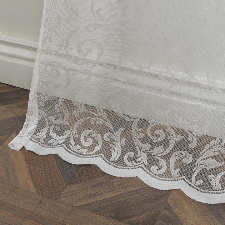 A white sheer voile curtain with scalloped embroidered edging, made to measure and shown with delicate detailing and soft flowing drape
