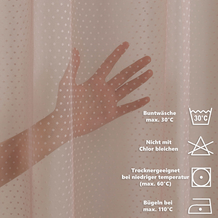 Hand touching a textured fabric with laundry care labels on a beige background