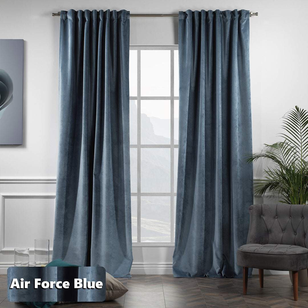 Tailored pinch pleat velvet curtain in muted blue shade, extra‑long drop and deep folds.