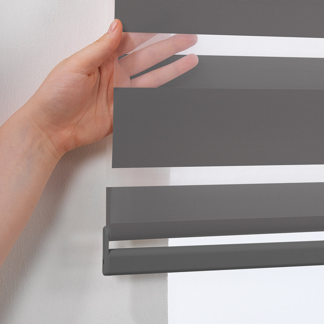 Made to measure anthracite zebra roller blind featuring deep smoky alternating sheer and dim‑out stripes for controlled light and enhanced privacy, highlighting its rich charcoal tone, smooth woven texture and sleek contemporary day‑and‑night blind design