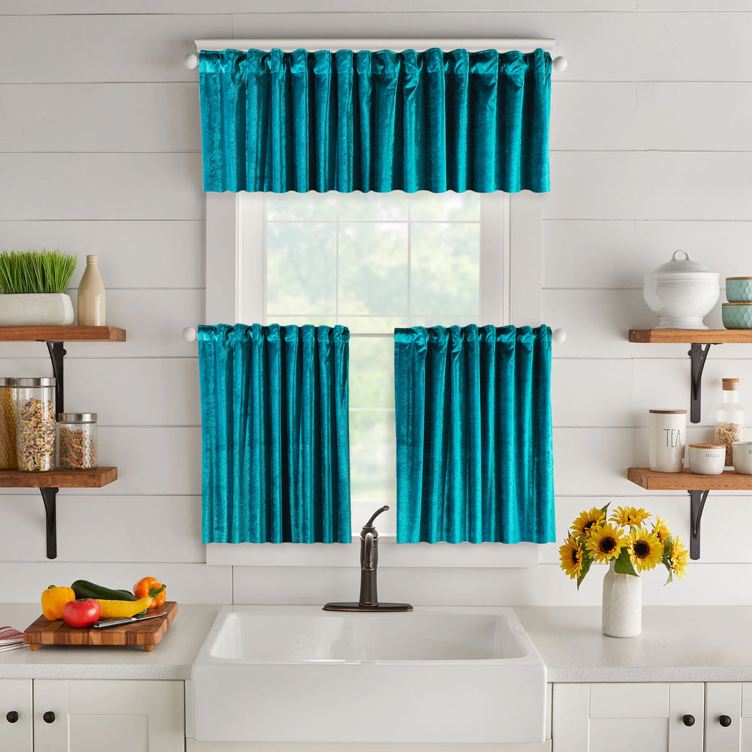 Turquoise kitchen curtain set above a sink with shelves and flowers in the background.