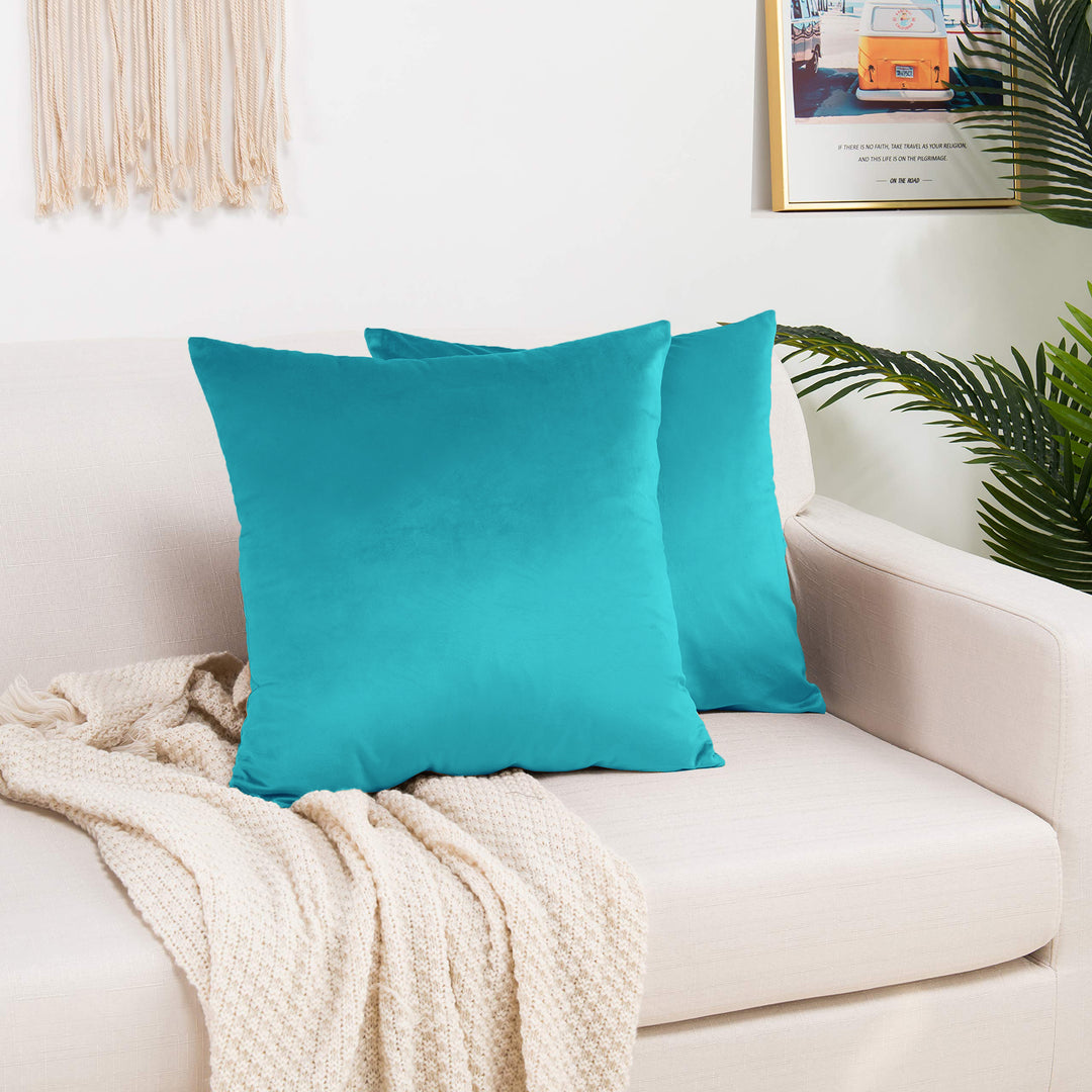 A made to measure cushion cover in bright azure‑blue shiny velvet, displaying a smooth glossy texture and neatly tailored seams for a vibrant premium appearance