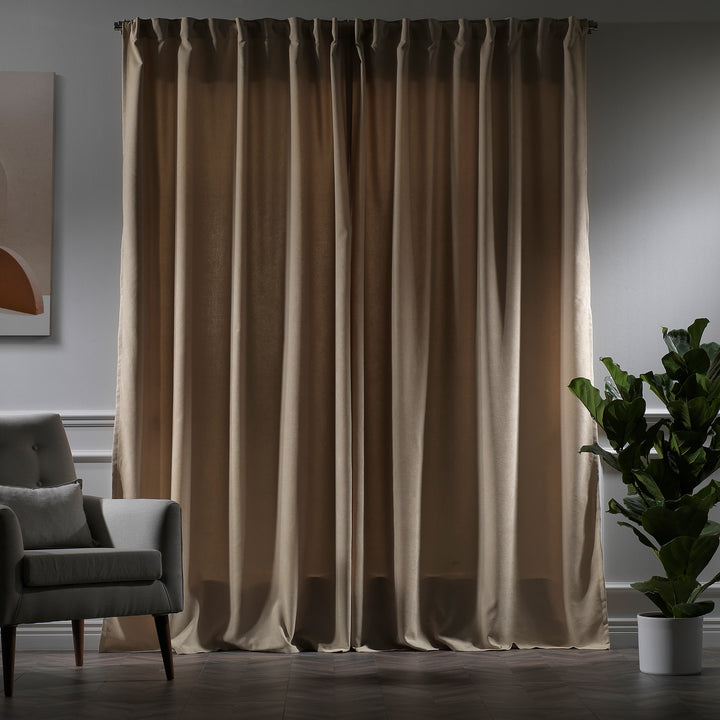 Soft beige velour curtains photographed in low light, showing dense weave, subtle sheen and elegant tailored fall.