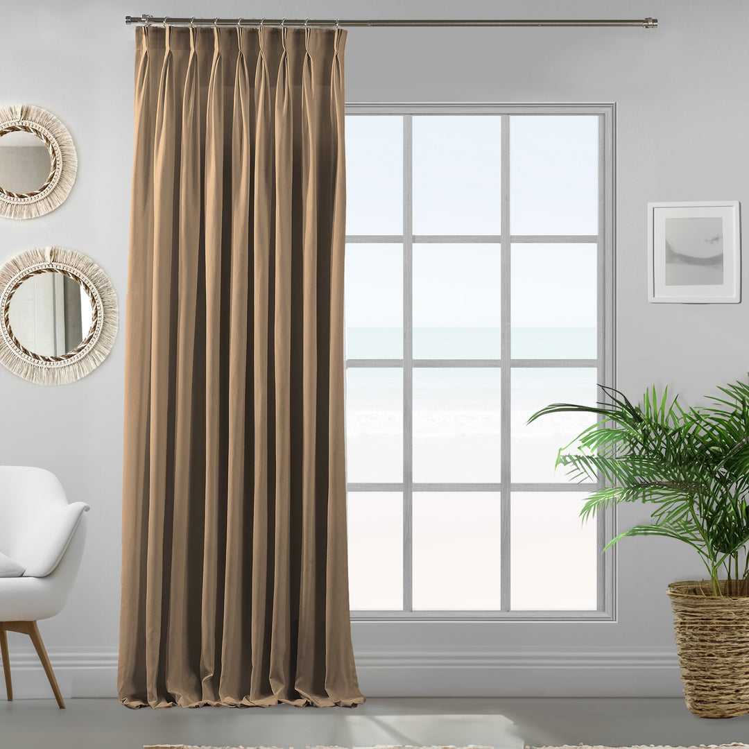 Pinch pleated beige velour curtain panel showing smooth pile texture, warm neutral tone and elegant soft drape.