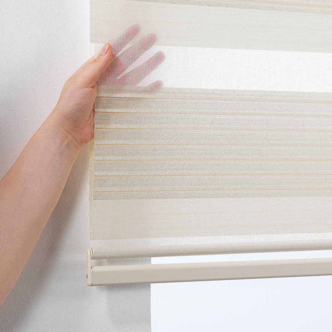 Made to measure beige thick pleated linen‑textured zebra roller blind featuring layered sheer and dim‑out stripes for warm natural light control and subtle privacy, highlighting its earthy beige tone, rich fabric texture and premium pleated day‑and‑night blind design
