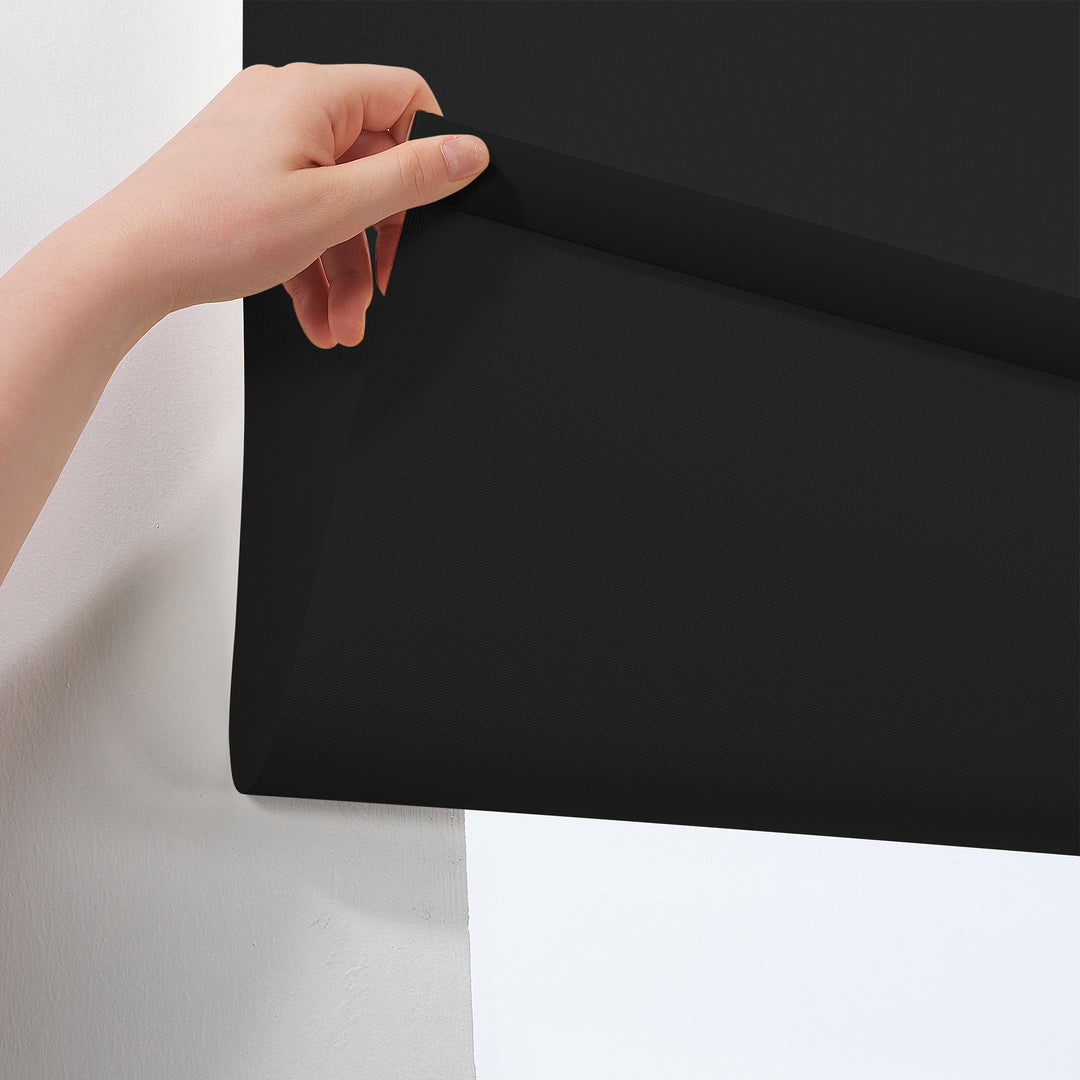  A close‑up of a deep black room darkening roller blind made to measure, showing its smooth matte texture and refined premium finish
