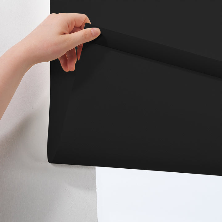  A close‑up of a deep black room darkening roller blind made to measure, showing its smooth matte texture and refined premium finish