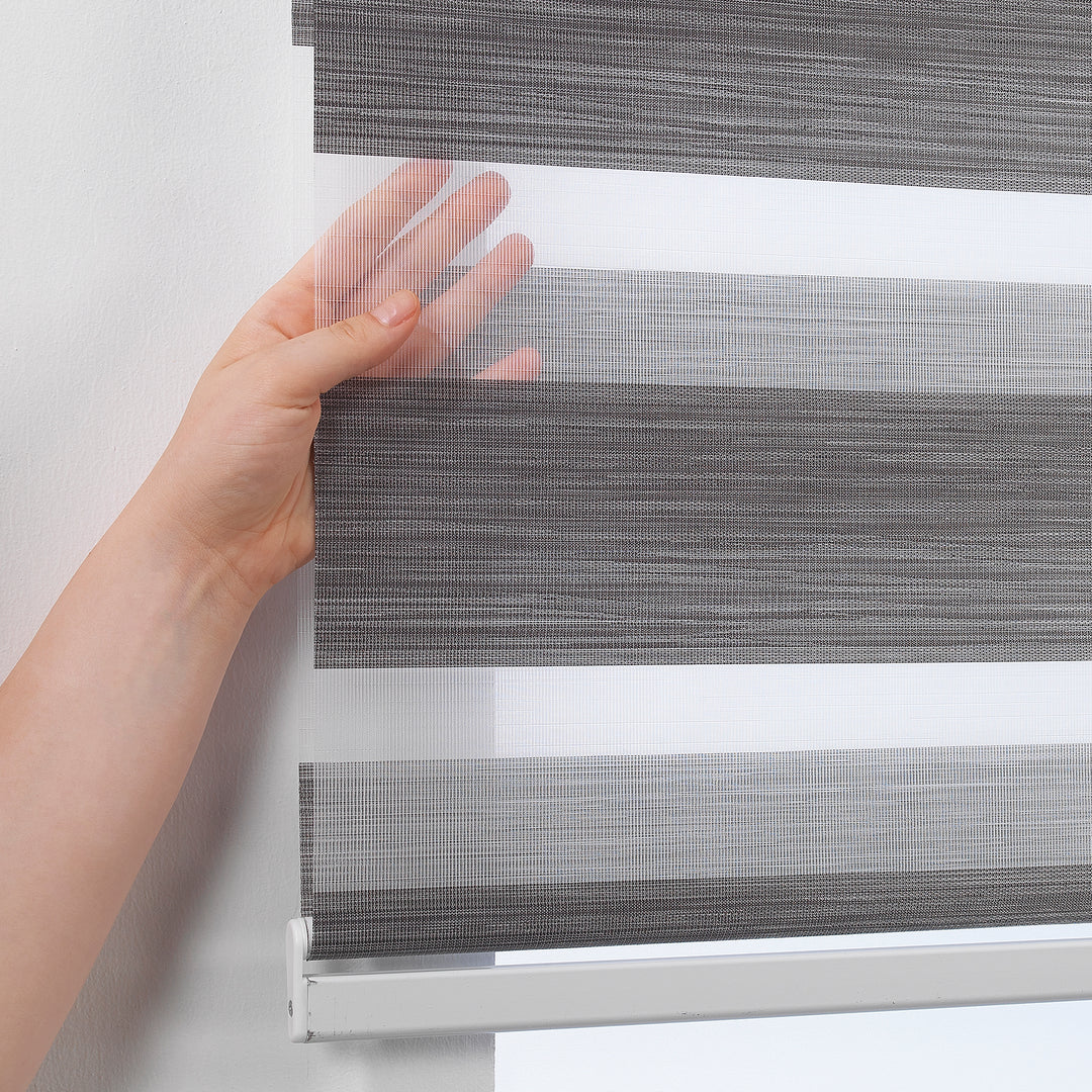 Made to measure zebra roller blind in black, designed with alternating sheer and opaque horizontal stripes for adjustable light control and privacy, highlighting the bold black tone, smooth texture and modern day‑and‑night blind style.