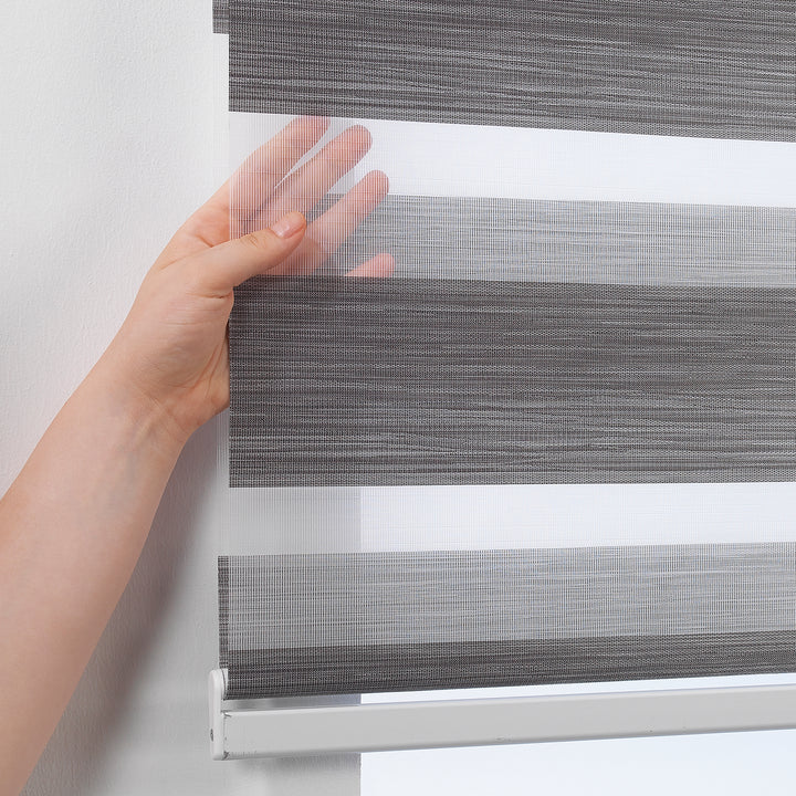 Made to measure zebra roller blind in black, designed with alternating sheer and opaque horizontal stripes for adjustable light control and privacy, highlighting the bold black tone, smooth texture and modern day‑and‑night blind style.