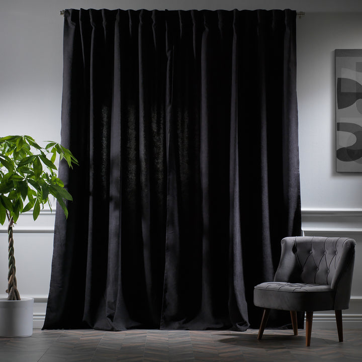  Black velour curtains photographed at night, showing dense weave, subtle sheen and refined tailored fall.