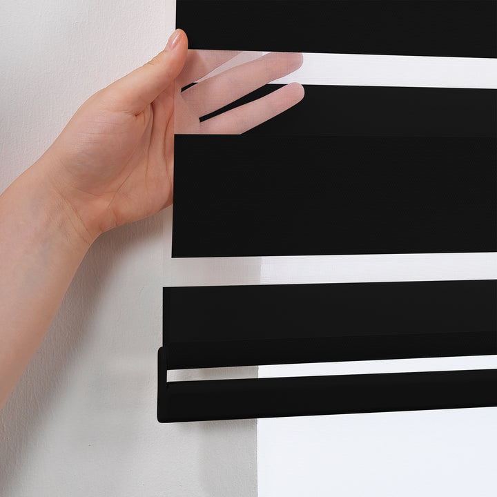 Made to measure solid black zebra roller blind featuring deep alternating sheer and dim‑out stripes that create a strong darkening effect and enhanced privacy, highlighting its bold black tone, smooth woven texture and modern day‑and‑night blind design.