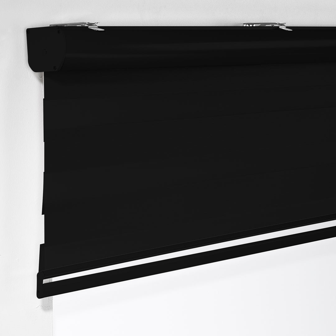 Made to measure solid black zebra roller blind featuring deep alternating sheer and dim‑out stripes that create a strong darkening effect and enhanced privacy, highlighting its bold black tone, smooth woven texture and modern day‑and‑night blind design.