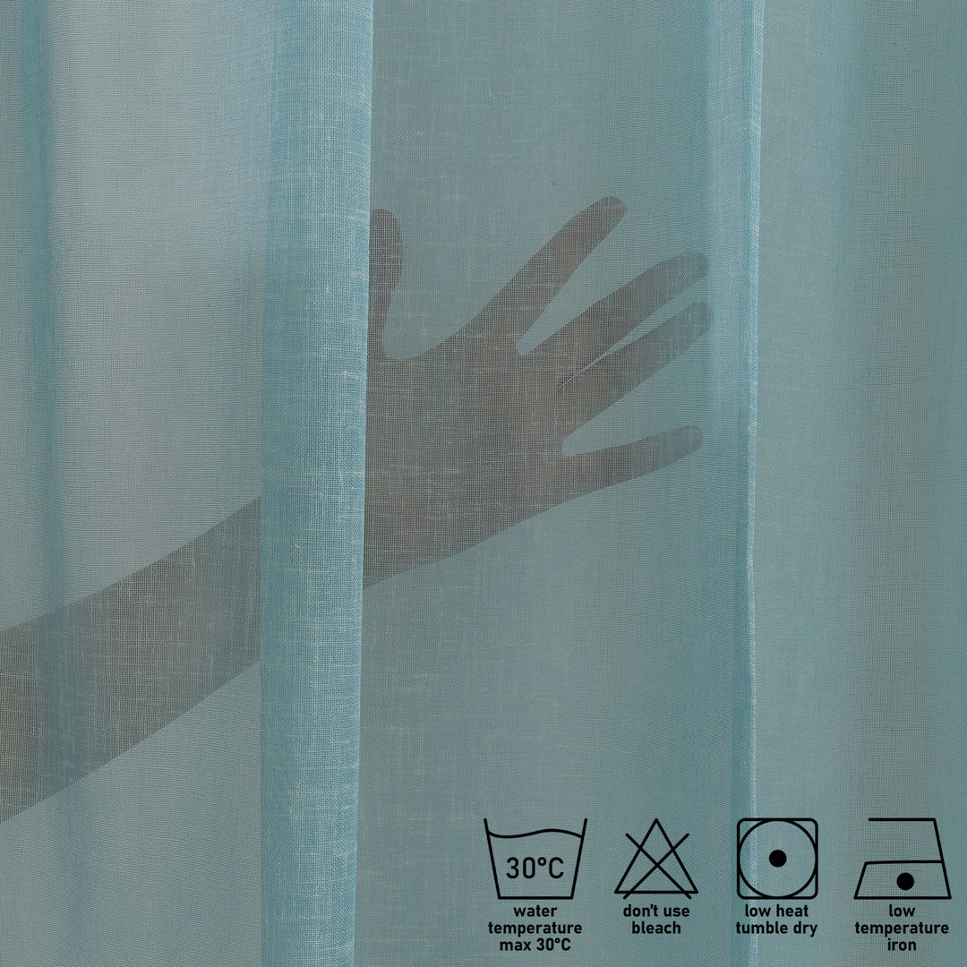 Washing label and fabric detail of blue linen sheer curtain showing weave and care instructions.
