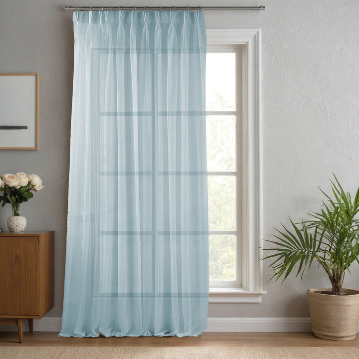 Blue linen‑sheer curtain made to measure with crisp pinch pleats and cool light‑filtering texture.