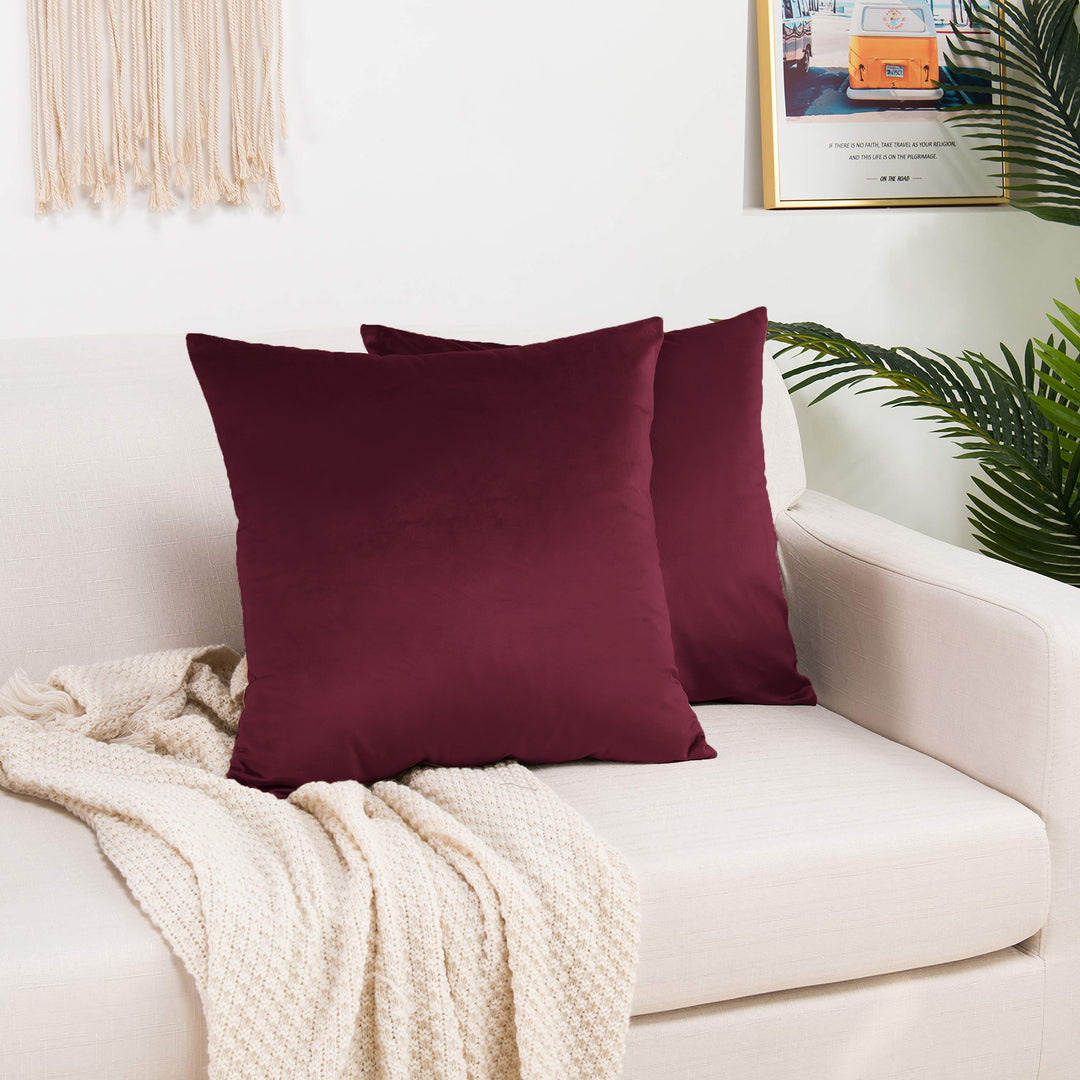 A made to measure cushion cover in deep burgundy shiny velvet, shown with a reflective plush texture and clean structured edges for a bold luxurious look