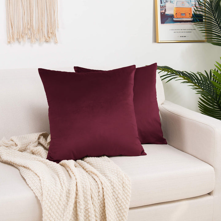 A made to measure cushion cover in deep burgundy shiny velvet, shown with a reflective plush texture and clean structured edges for a bold luxurious look