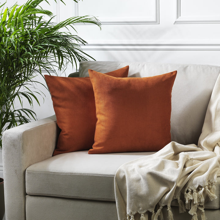 A made to measure cushion cover in deep burnt‑orange velour, shown with a lightweight plush texture and neatly tailored edges for a warm decorative finish