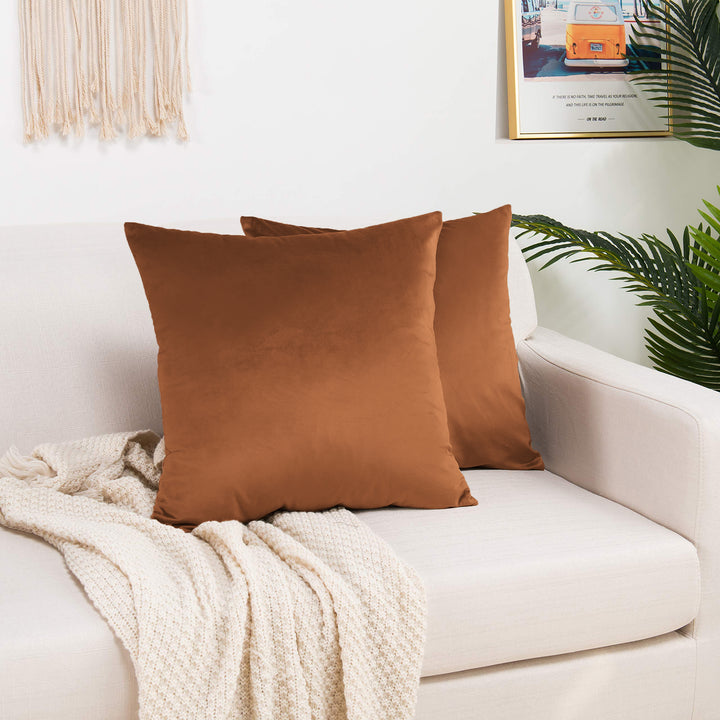 A made to measure cushion cover in deep burnt‑orange shiny velvet, displaying a smooth glossy surface and neatly finished seams for a rich warm finish