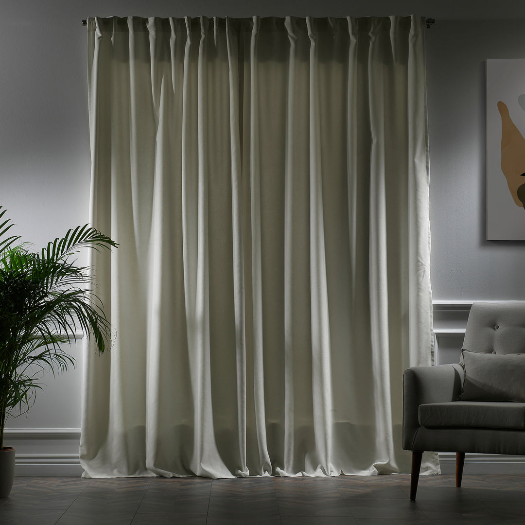 Cream velour curtains photographed closed, showing smooth pile texture, warm undertone and elegant soft drape.