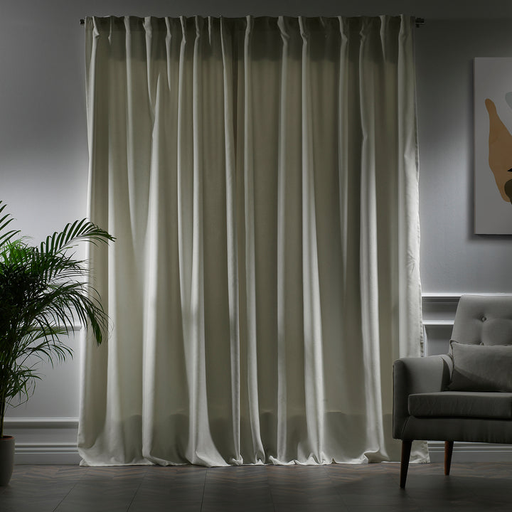 Cream velour curtains photographed closed, showing smooth pile texture, warm undertone and elegant soft drape.