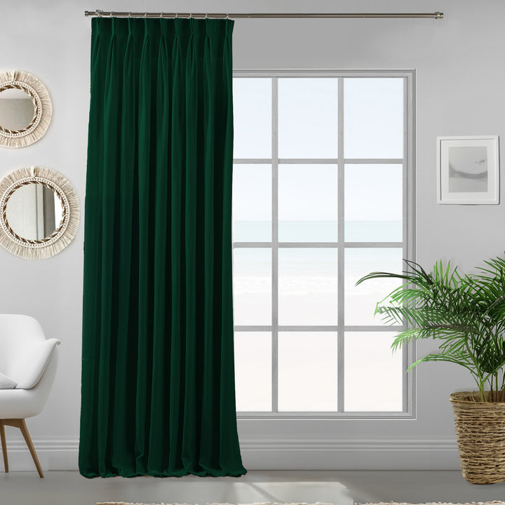 Pinch pleated dark green velour curtain panel showing soft drape and refined matte finish.
