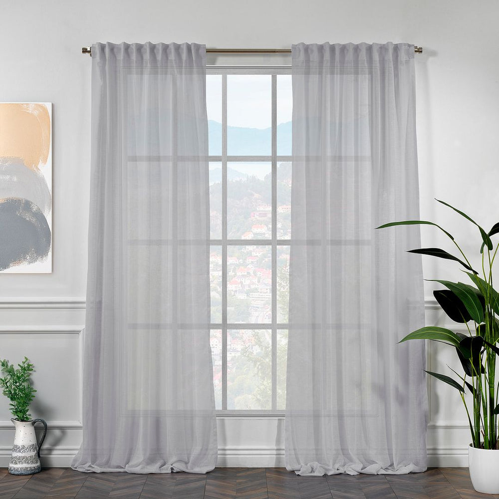 Macro view of a light grey linen semi-sheer curtain demonstrating its elegant light-filtering properties and soft glow