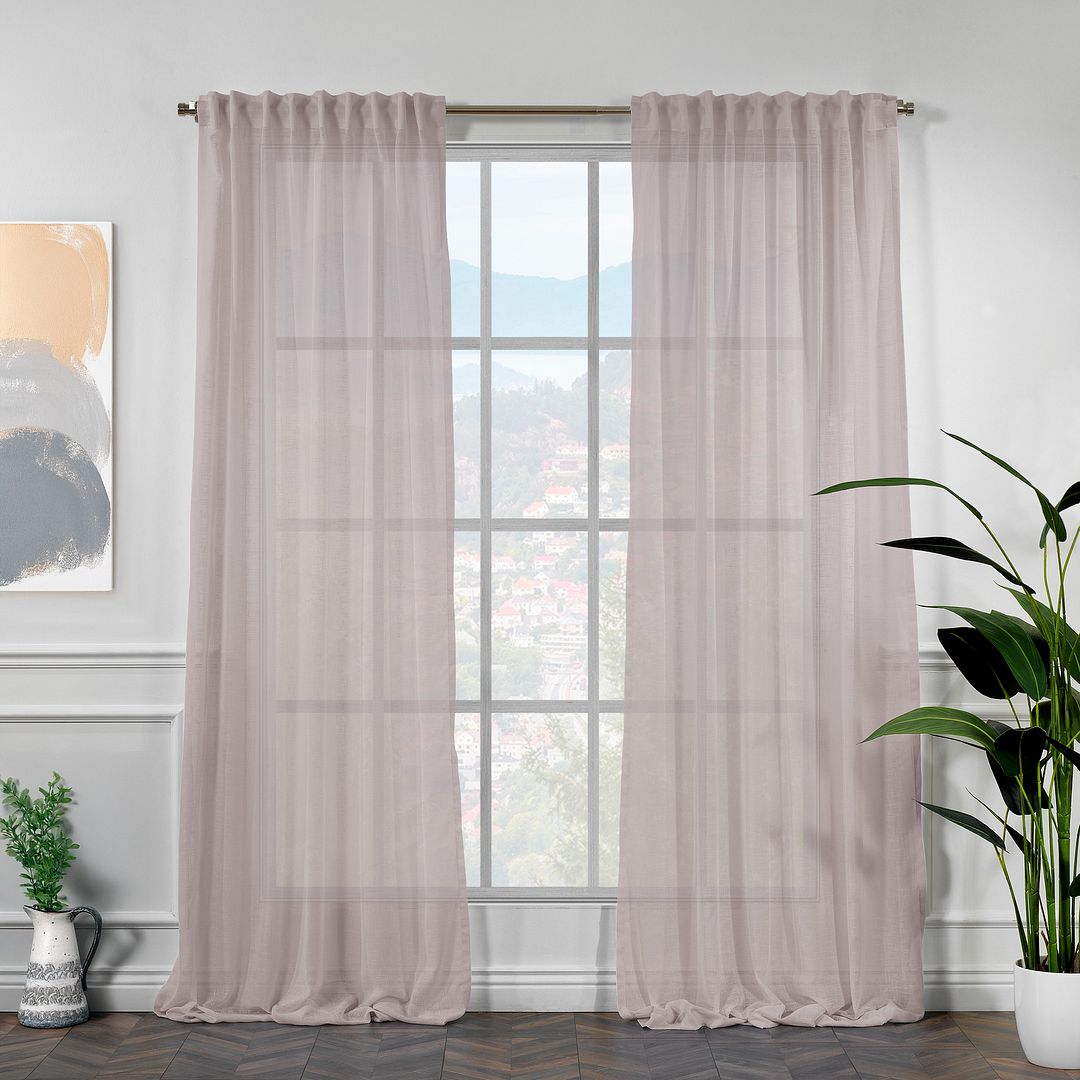 faux rose linen semi sheer curtains hanging in front of a window with a plant and artwork on the wall.