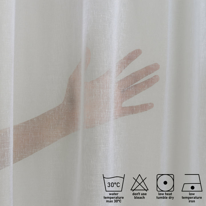 Washing label and fabric detail of ecru linen sheer curtain showing weave and care instructions.
