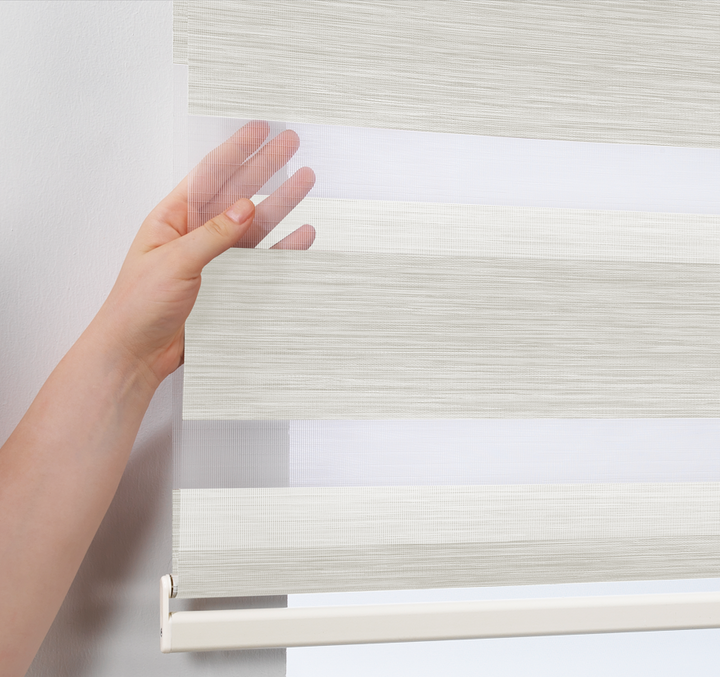 Made to measure zebra roller blind in ecru, featuring alternating sheer and opaque horizontal stripes for adjustable light control and privacy, showcasing the soft neutral tone, smooth texture and contemporary day‑and‑night blind design.