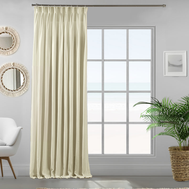 Pinch pleated ecru velour curtain panel showing soft drape and premium neutral tone.