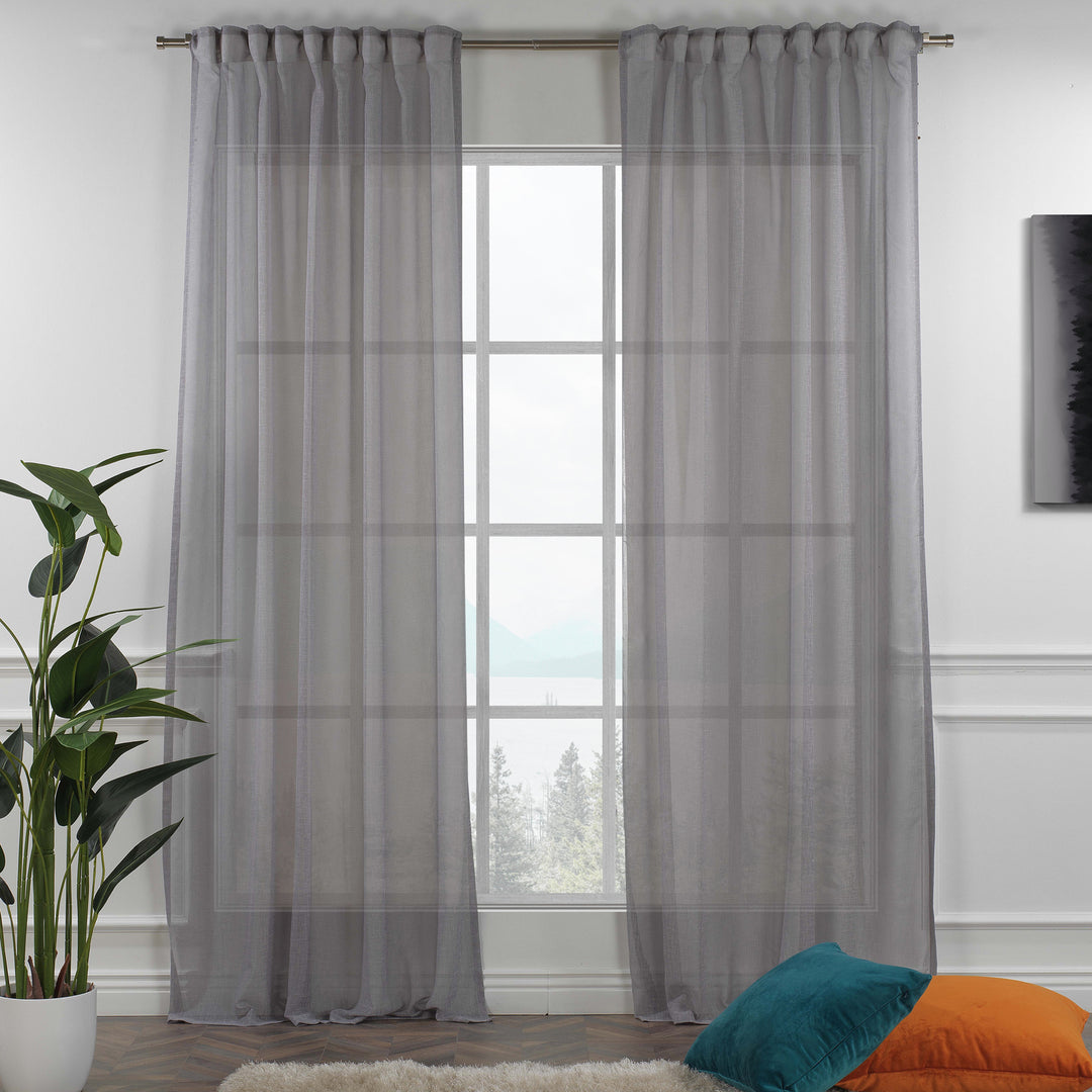 Grey linen sheer curtain with rod‑pocket header in a modern living room, soft diffused light and airy drape.