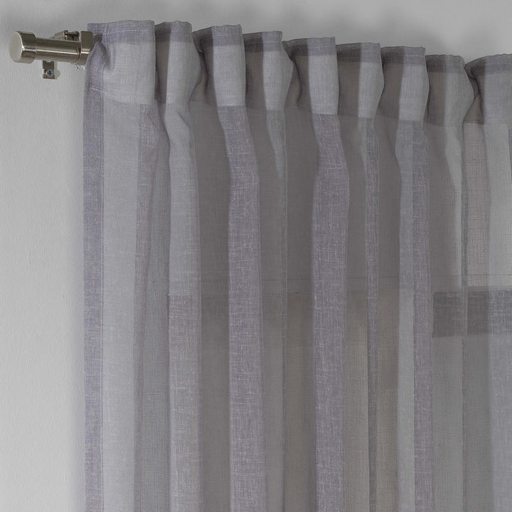 grey linen sheer curtain hanging in a contemporary bedroom, airy drape with soft folds.