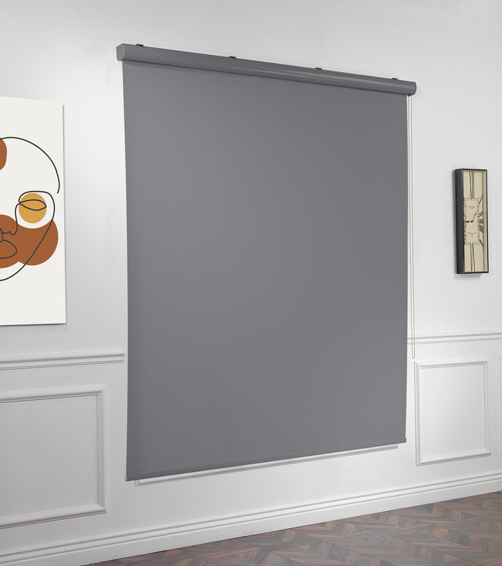 A made to measure grey room darkening roller blind captured with a smooth matte texture and neat straight edges reducing light gently