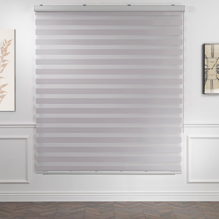 Made to measure solid silver zebra roller blind featuring subtle metallic‑toned alternating sheer and dim‑out stripes for sleek, adjustable light control and privacy, highlighting its light‑reflecting silver shade, smooth woven texture and contemporary day‑and‑night blind design.