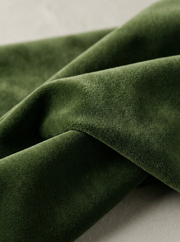 Close-up of green velvet fabric on a neutral background