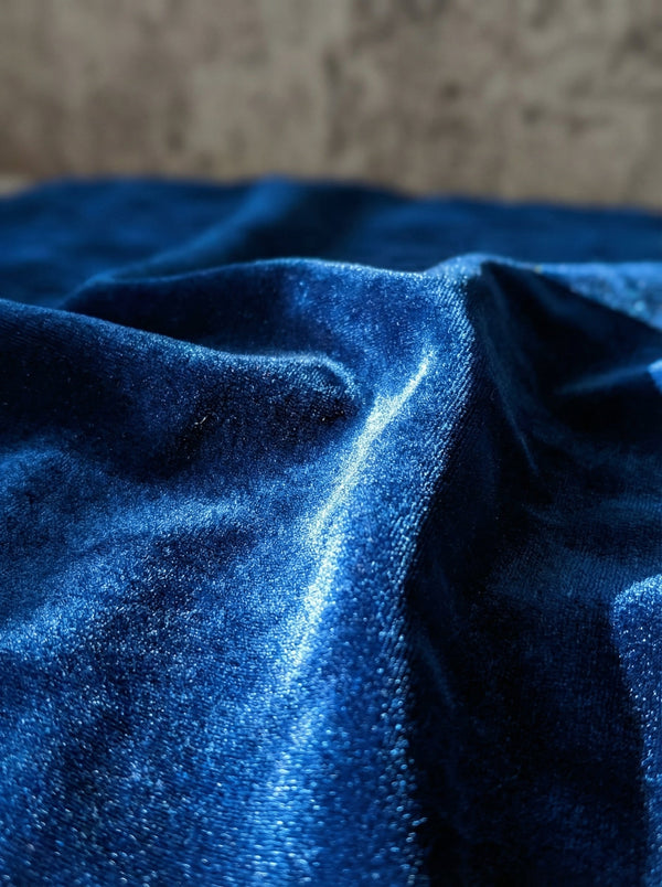 Close-up of blue shiny velvet fabric with a textured surface