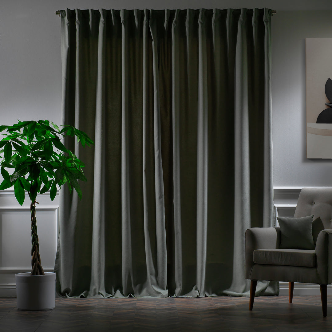 Leaf green velour curtains photographed at night, showing deep tone, dense weave and elegant soft drape.