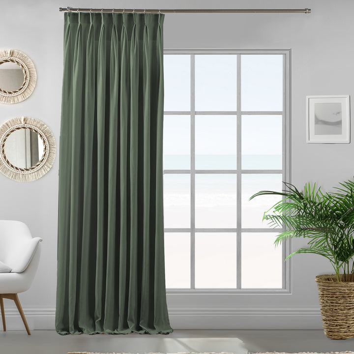 Pinch pleated leaf green velour curtain panel showing soft drape and refined matte finish.
