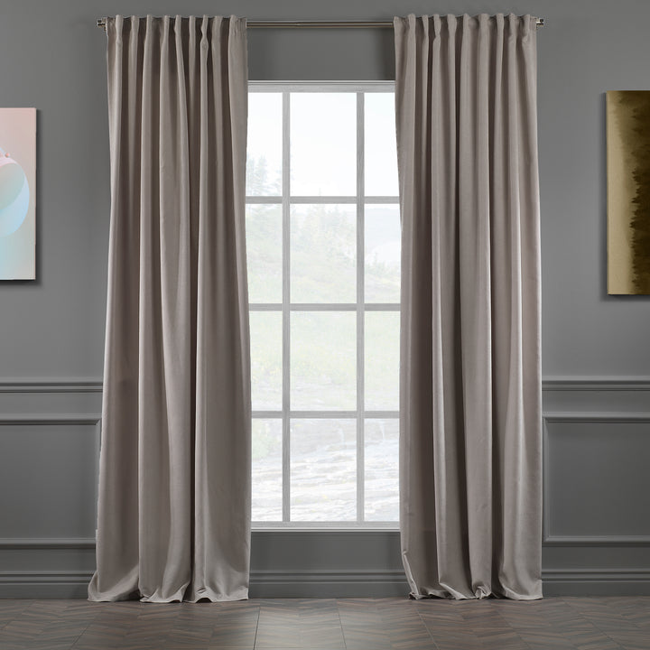 Light stone velour curtains against dark background, highlighting fabric depth, matte finish and elegant drape.