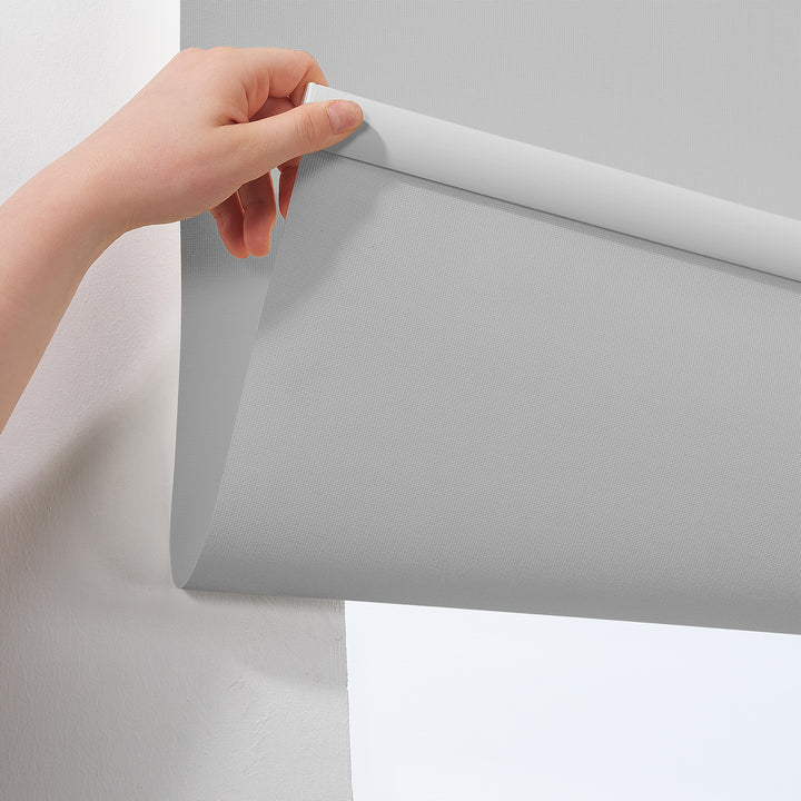 A light grey room darkening roller blind made to measure, photographed with a smooth matte finish and refined minimal styling for gentle light reduction