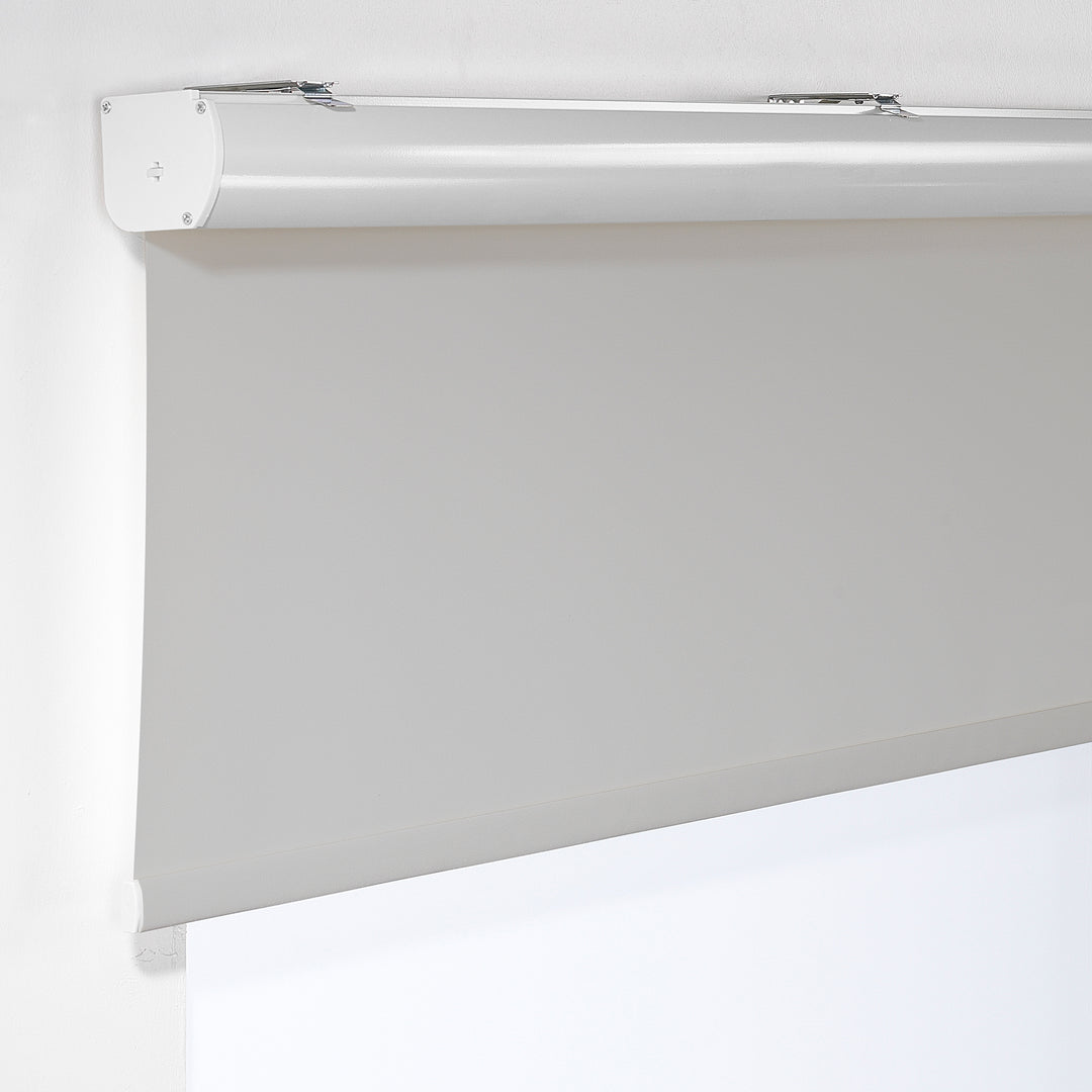  A light grey room darkening roller blind made to measure, shown lowered with a smooth matte surface and clean minimal edges softening incoming light