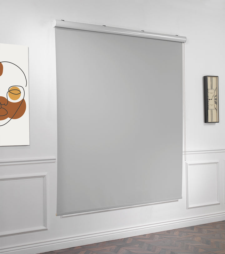 A light grey room darkening roller blind made to measure, photographed from a soft angle highlighting its matte finish and tidy straight lines