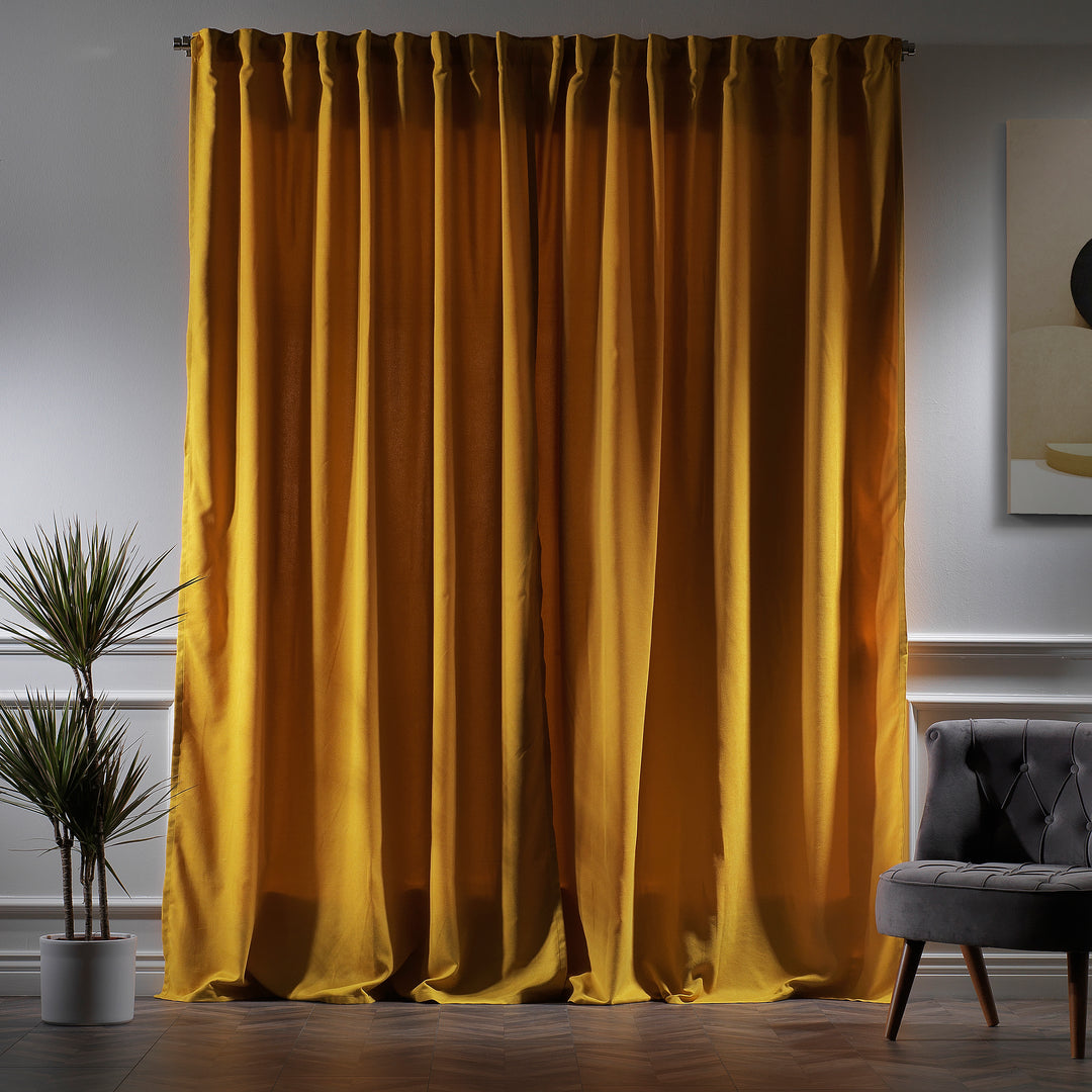 Mustard yellow velour curtains photographed at night, showing warm tone, dense weave and elegant soft drape.
