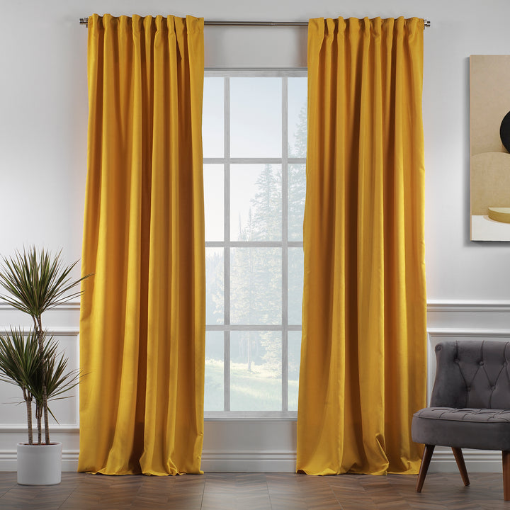 Mustard yellow velour curtains shown in daylight, highlighting smooth pile texture and rich colour depth.