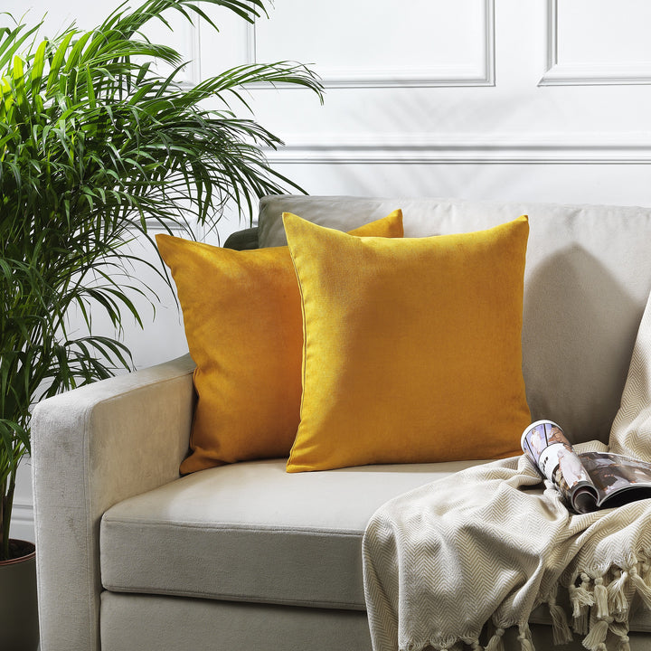 A made to measure cushion cover in warm mustard velour, featuring a soft lightweight surface and clean refined seams for a vibrant premium look