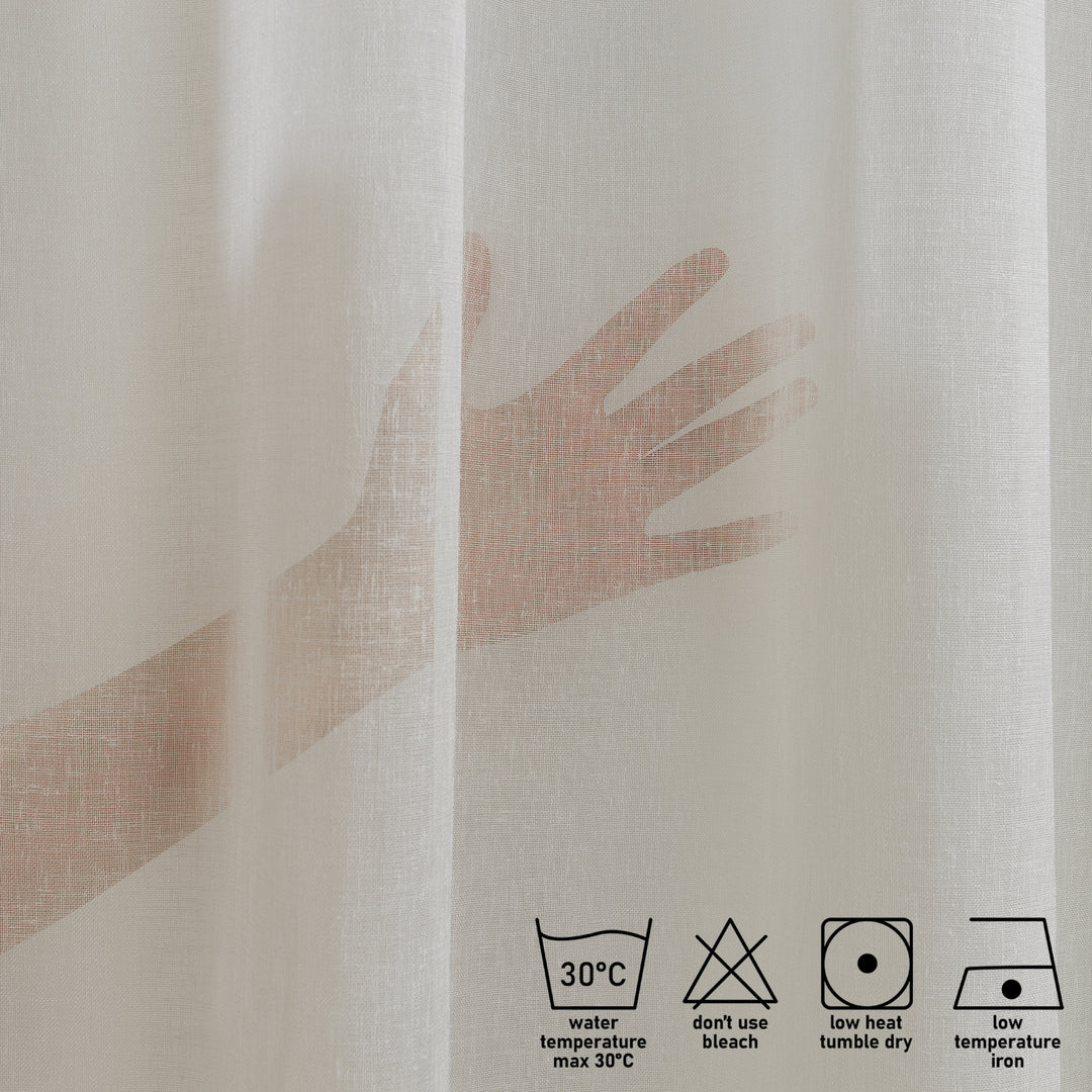 Washing label and fabric detail of off‑white linen sheer curtain showing weave and care instructions.