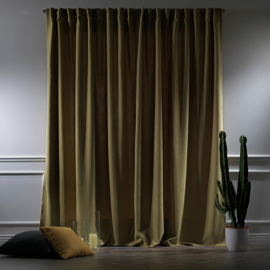 Olive green velour curtains photographed at night, showing dense weave, subtle sheen and rich colour depth.