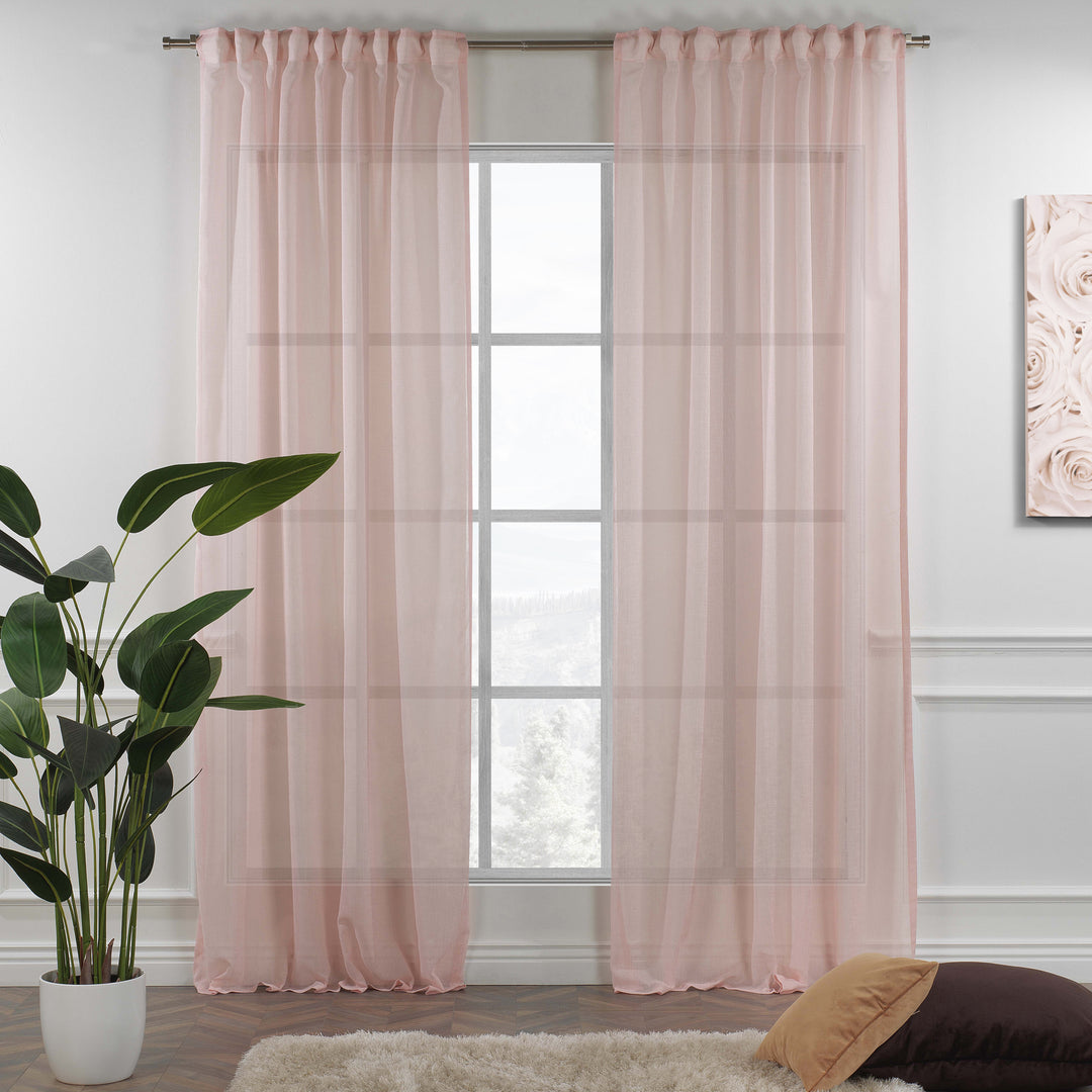 Pink linen sheer curtain with rod‑pocket header hanging in a bright living room, soft natural light and airy drape.