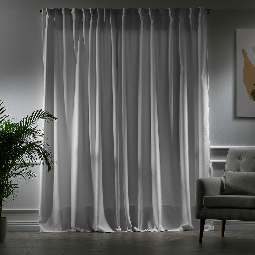 Pure white velour curtains photographed closed, showing dense weave, soft drape and elegant matte texture