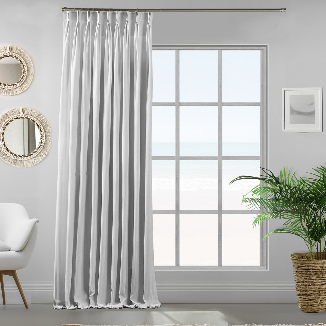 Pure white velour curtains photographed from an angle, showing soft drape, matte finish and refined texture.